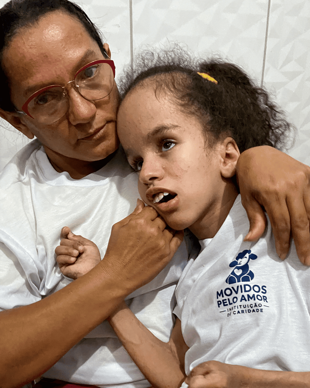 Maria Sônia abraçada com Ana Júlia usando camiseta do instituto